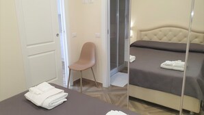 A hotel room with a bed, a chair, and a table with towels. - Appartamenti Borgo Panoramico N.6 (Tropea)