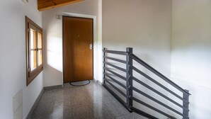 A hallway with a wooden door, a window, and a metal railing. - Leisure & Business (Buttrio)