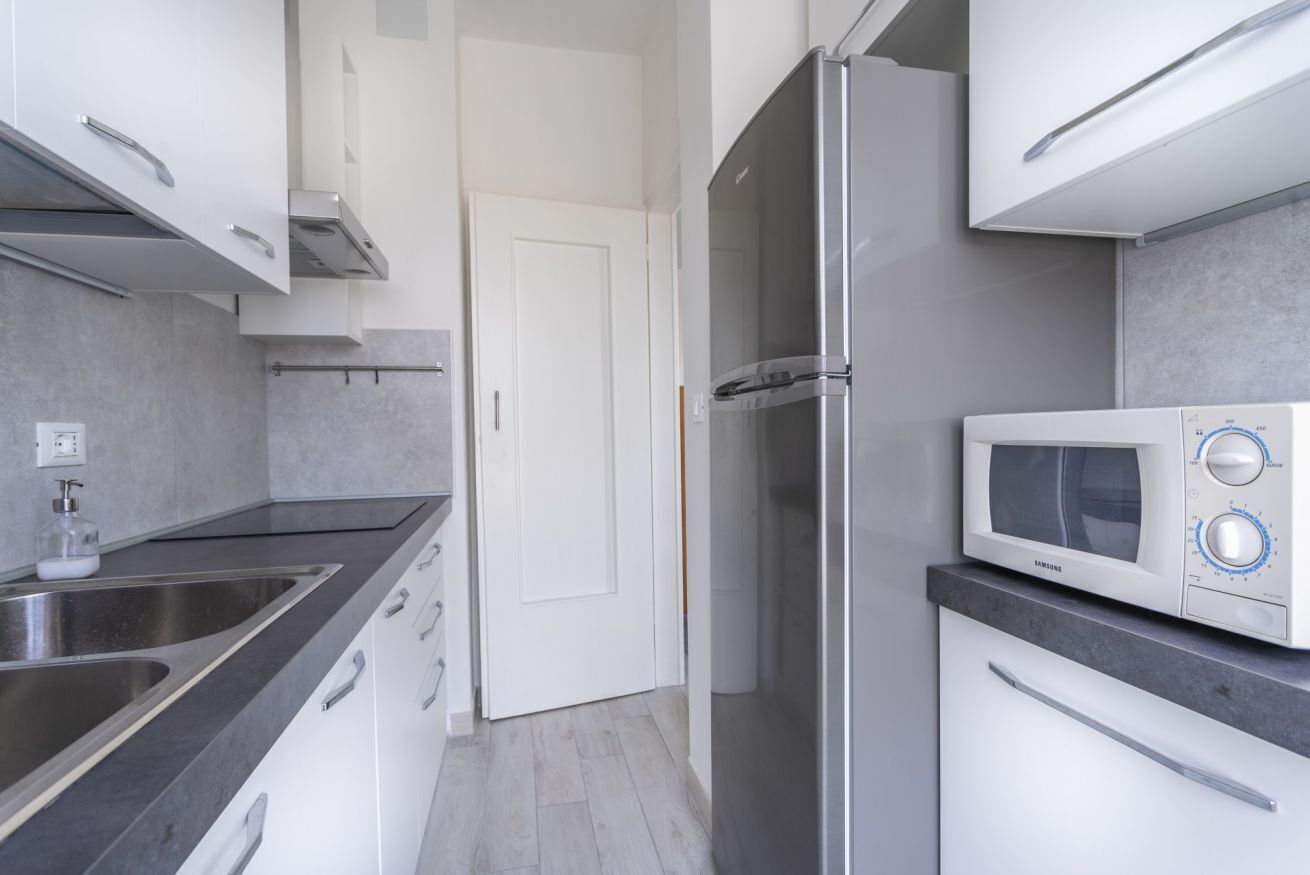 A modern kitchen with stainless steel appliances, a microwave, and a refrigerator.