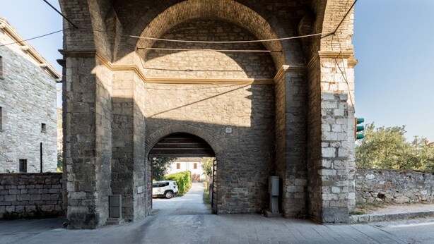 A stone archway with a paved road underneath. - Borgo Santa Lucia Apartment with Private Parking & Garden (Gubbio)