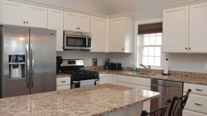 A modern kitchen with white cabinets, stainless steel appliances, granite countertops, and a built-in oven. - 4 BR / 2 Bath / Town Center -Top Floor w/ Roofdeck (Ocean City)