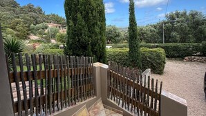 Une terrasse avec un sol carrelé et une clôture en bois.