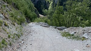 Un paisaje montañoso con un camino de grava que serpentea por un valle.
