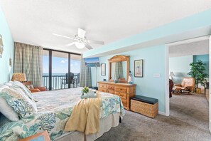 Un dormitorio con cama, cómoda y vista al océano.