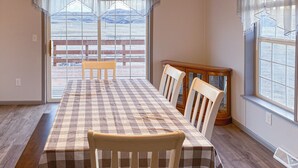 A dining area with a checkered tablecloth, wooden chairs, and a bench. - FOOTHILLS LOOKOUT INN -Come home to Montana! (Havre)