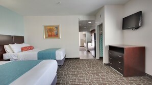 A hotel room with two beds, a TV, a desk, and a painting on the wall. - Deluxe One -Bedroom Condo! (Ocean City)