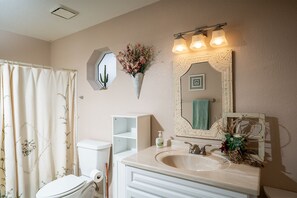 A bathroom with a toilet, sink, and shower curtain.
