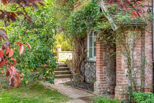 A brick building with a narrow pathway leading to a set of stairs.