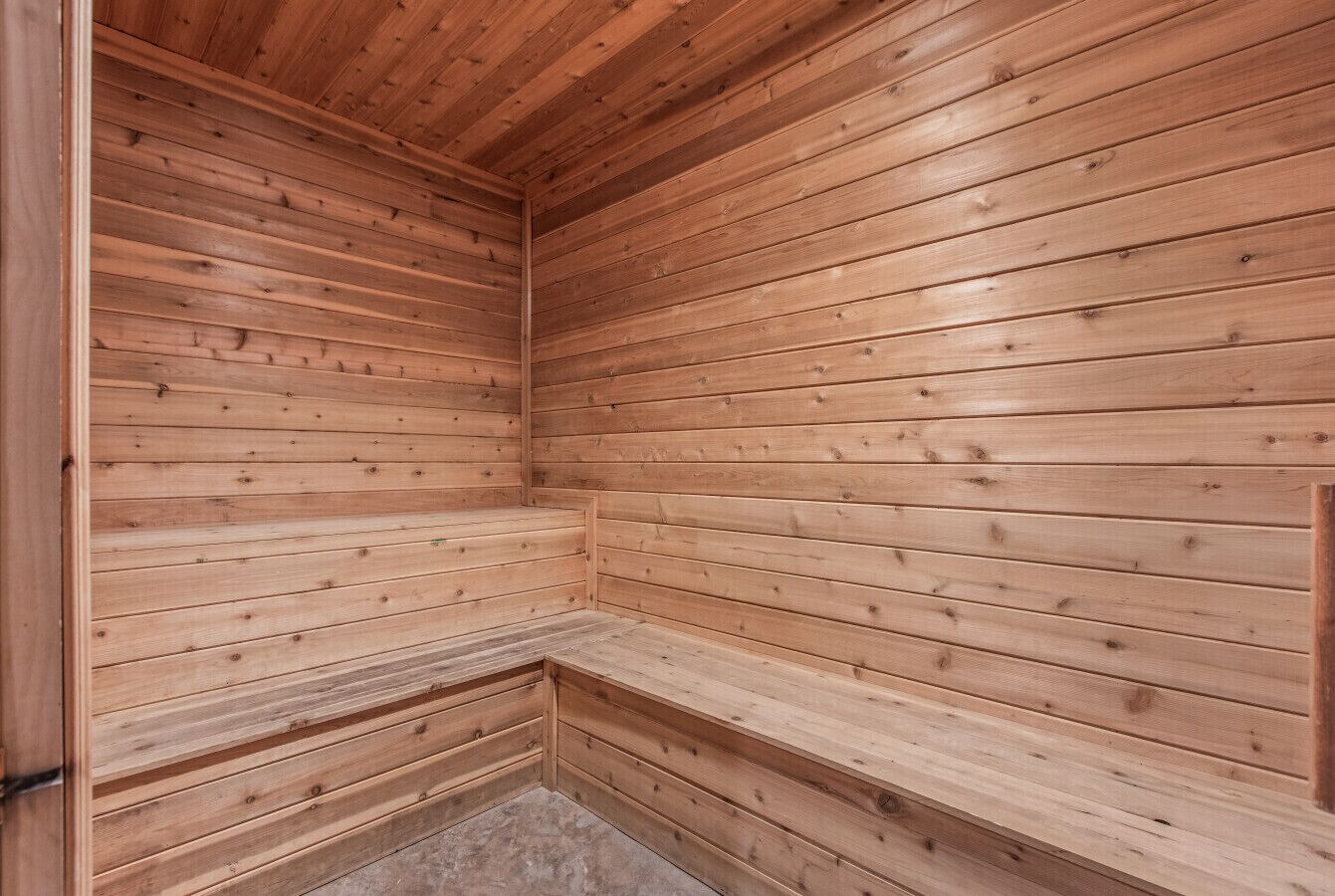 Un sauna avec des murs et des bancs en bois.