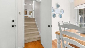 A staircase leading to a bedroom with a bed and a nightstand.