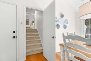 A staircase leading to a bedroom with a bed and a nightstand.