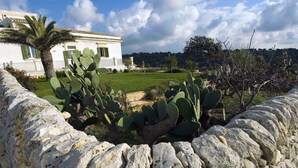 A stone wall with cacti, a white building with green shutters, and a clear sky. - Nice apartment with private terrace. Shared pool. In Donnafugata, Sicily (Donnafugata)