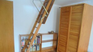 A room with a wooden ladder, wooden wardrobe, and a bookshelf. - Apartment - For Güstrow: Apartment Bergfeld (Lalendorf)