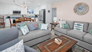A modern living room with grey sofas, patterned cushions, and a wooden coffee table. - Bayfront with great patio! (San Diego)