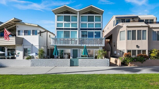 A modern multi-story hotel with a central courtyard, outdoor seating, and a flag. - Bayfront with great patio! (San Diego)