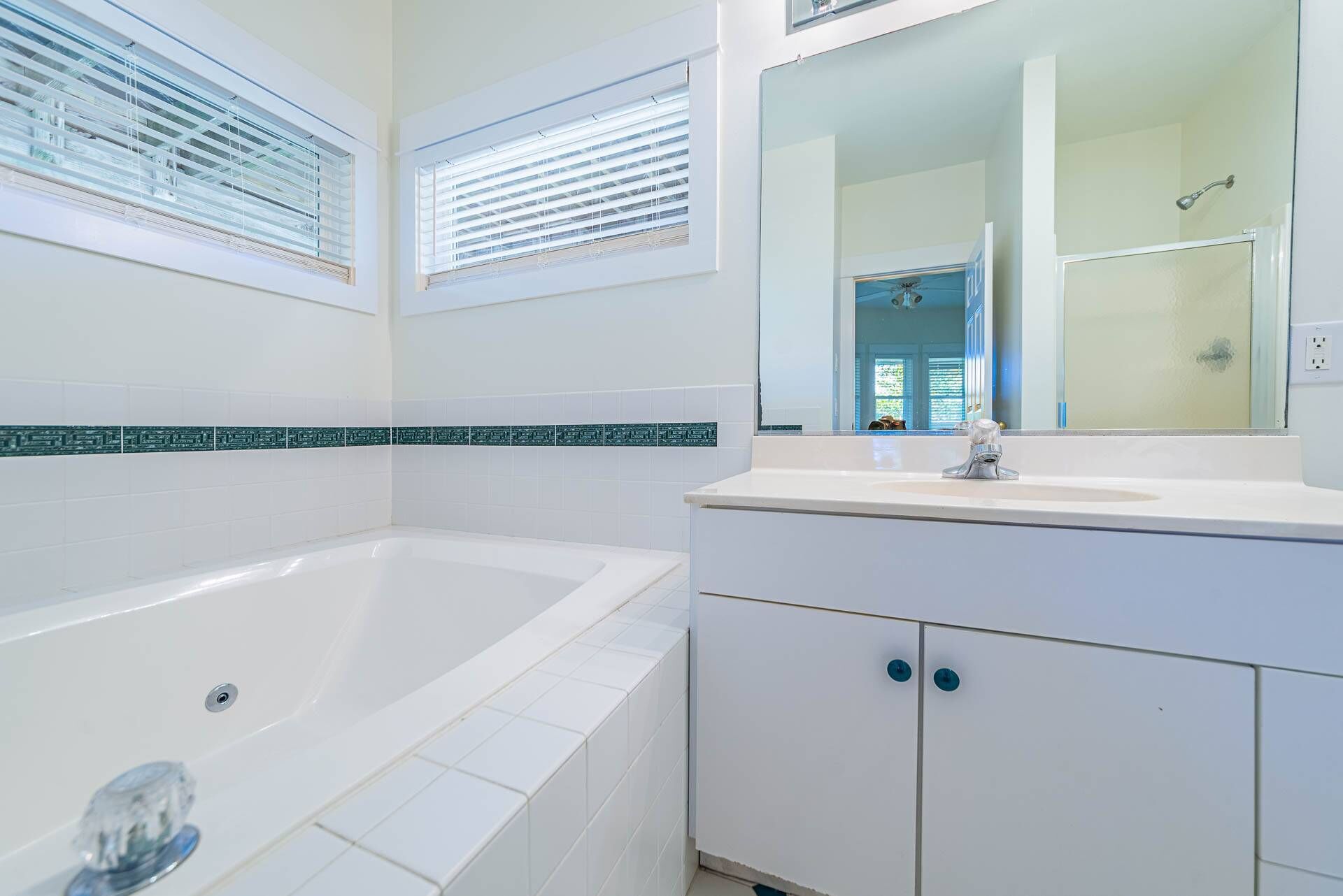 A bathroom with a bathtub, a sink, and a mirror.
