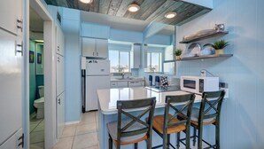 A modern kitchen with a central island, white appliances, and blue walls. - 33❤️Waterfront❤️Fishing Dock❤️Close to beach❤️King Bed (BreckenridgeCorpus Christi)