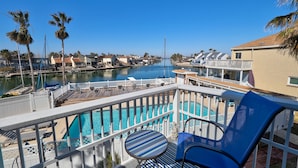 A pool area with a view of a marina, palm trees, and waterfront houses. - 33❤️Waterfront❤️Fishing Dock❤️Close to beach❤️King Bed (BreckenridgeCorpus Christi)