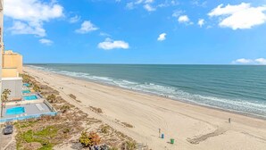 A beach view from a high-rise hotel with a pool area and a pier in the distance. - Landmark 708 (Myrtle Beach)