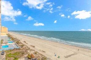 A beach view from a high-rise hotel with a pool area and a pier in the distance. - Landmark 708 (Myrtle Beach)
