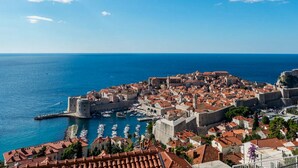 A coastal city with historic architecture, a prominent castle, and a marina. - Guesthouse Home Sweet Home - Double Room with Shared Terrace (Dubrovnik)