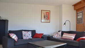 Una sala de estar moderna con dos sofás, una mesa de centro y un tapete estampado.