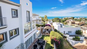 A modern hotel with a pool, outdoor seating, and a view of the sea. - Villa Jimena by Mabiente Properties by Mabiente Properties (Mijas)