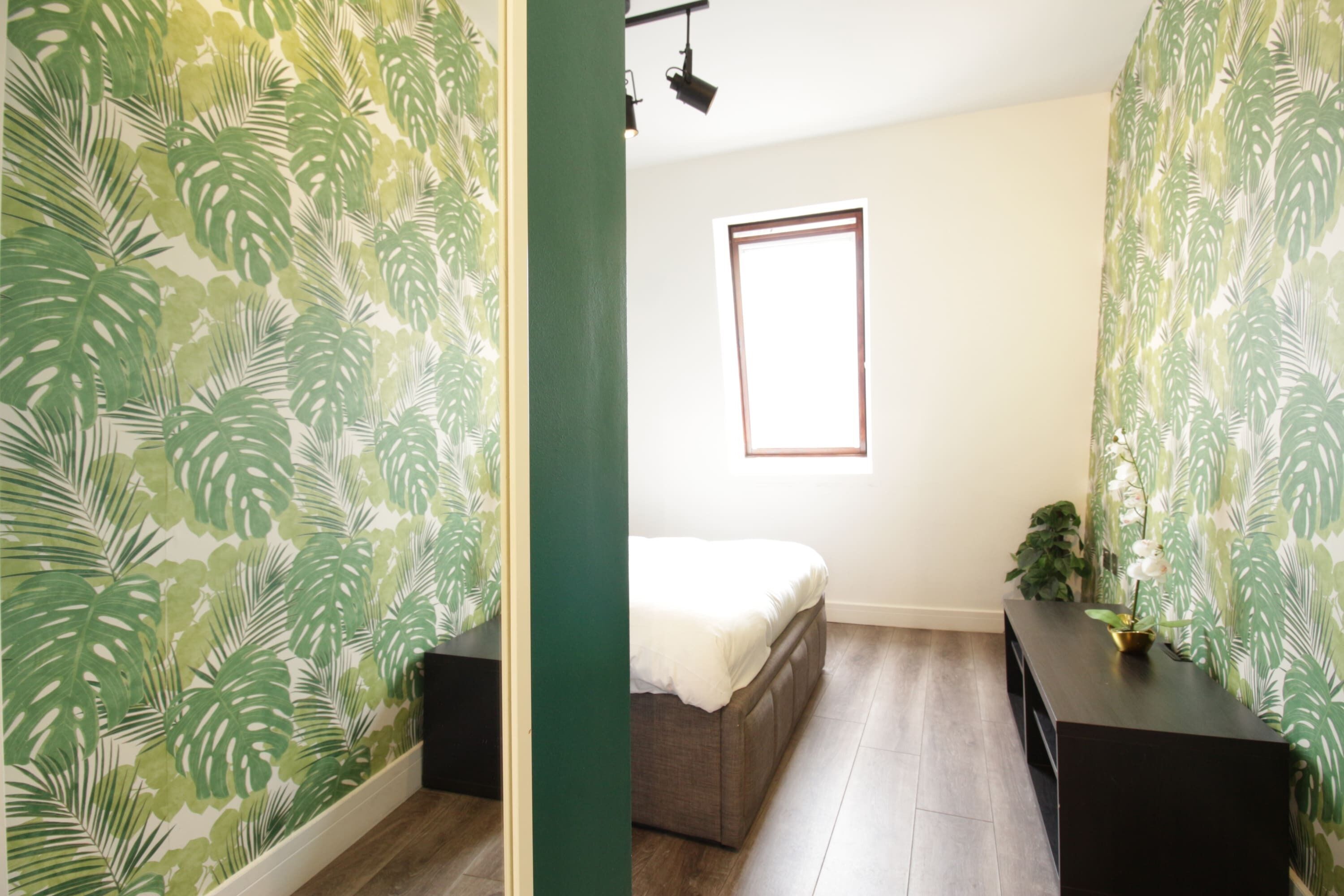 A room with a bed, a small table, and a window.