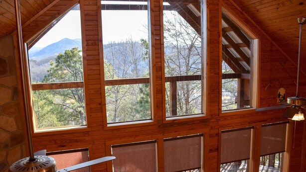 A cabin with large windows, wooden interior, and a view of mountains and trees. - Hiker's Point - Cabin In The Smokies (Sevierville)