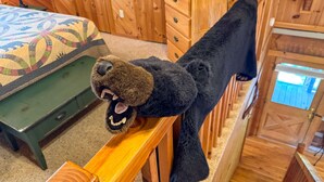 A dog in a room with wooden furniture and a patterned bedspread. - Sitting Rock - Cabin In The Smokies (Sevierville)