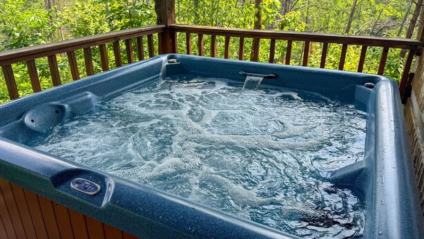 A hot tub on a wooden deck with a natural backdrop. - Sitting Rock - Cabin In The Smokies (Sevierville)