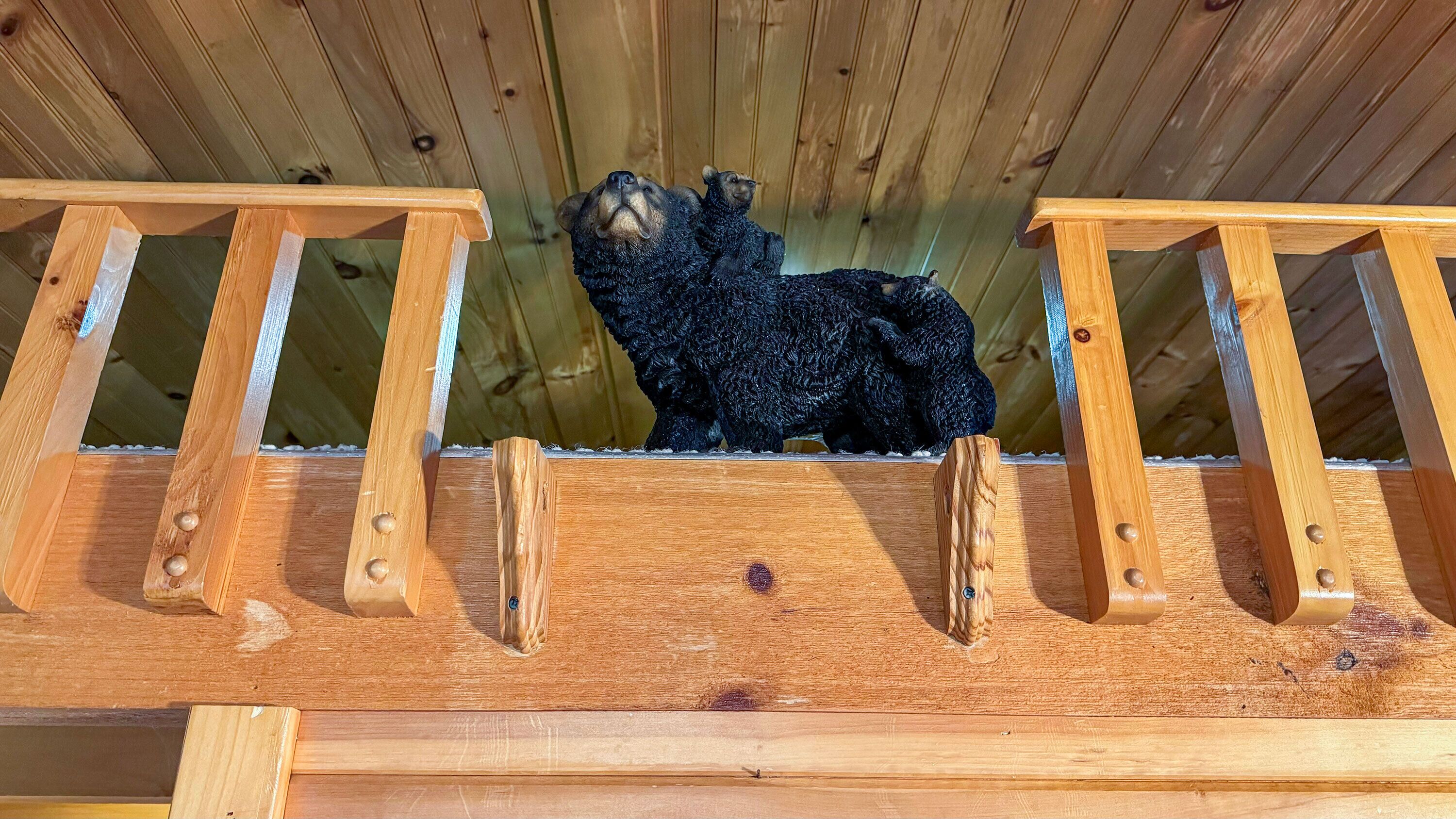 A wooden structure with two bear figurines positioned on top.