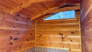 Simple, cozy space with a sloped ceiling and a small window.
