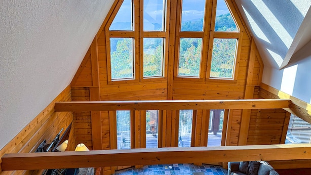 A wooden attic room with skylights, a sloped ceiling, and a view of trees. - Harvest Moon - Cabin In The Smokies (Sevierville)