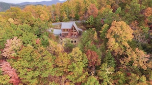 A wooden cabin surrounded by dense forest with a clear view of the surrounding landscape. - Harvest Moon - Cabin In The Smokies (Sevierville)