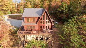 A wooden cabin with a balcony, surrounded by trees. - Harvest Moon - Cabin In The Smokies (Sevierville)