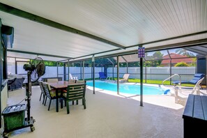 A covered outdoor area with a pool, lounge chairs, and a table with chairs. - Renovated Naples Oasis w/ Pool: 2 Mi to Beach (Naples)