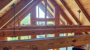 A high-ceilinged wooden structure with multiple skylights and a central window, likely part of a building's interior.