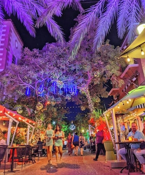 Outdoor dining area with tables and chairs, offering a festive atmosphere.
