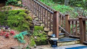 A wooden staircase with a 'Welcome' sign, surrounded by lush greenery and moss. - Sweet Serenity - Easy to Access Cabin By A Small Mountain Stream in Wears Valley (Sevierville)