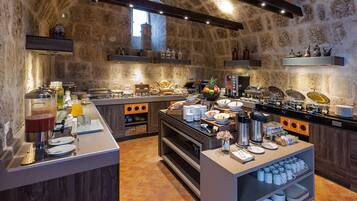 Una cocina amplia con paredes de piedra, electrodomésticos modernos y una variedad de alimentos y bebidas a la vista.