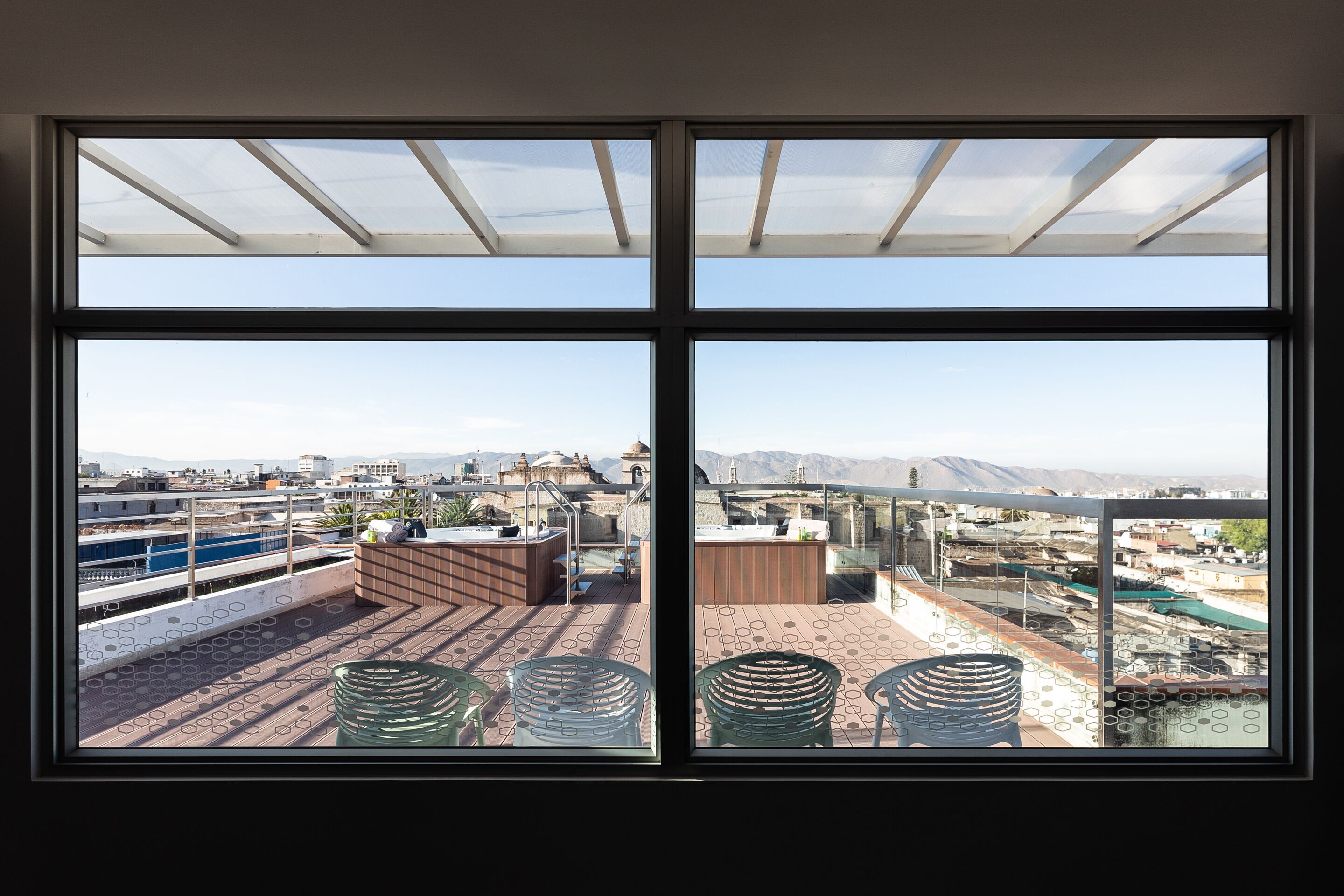 A rooftop terrace with a view of the cityscape, including a pool and outdoor seating area.