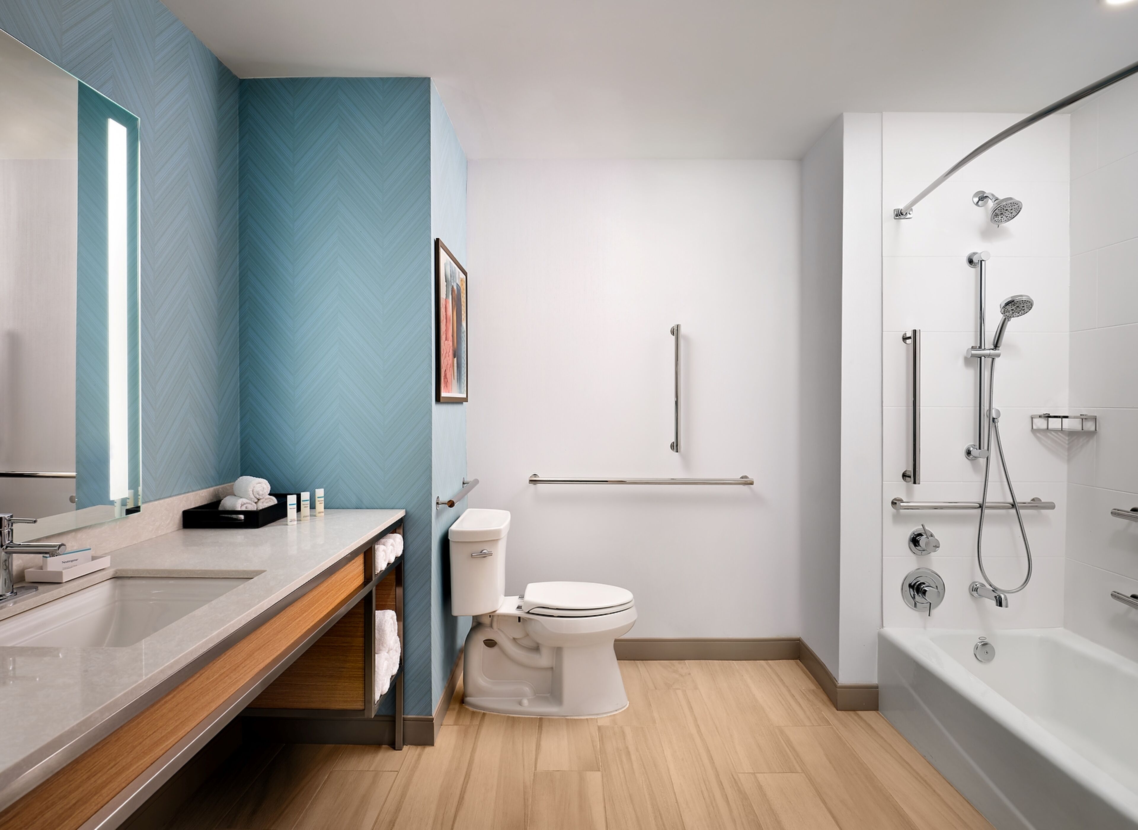 A modern bathroom with a white toilet, a sink with a mirror, and a shower area.