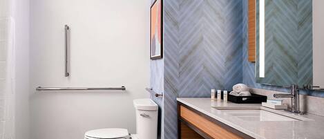 Une salle de bain moderne équipée de toilettes, d’un lavabo et d’une douche.