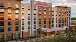 A Hilton Garden Inn hotel with a modern design, featuring multiple floors and a prominent entrance. - Hilton Garden Inn Grapevine at Silverlake Crossing (Grapevine)