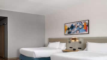 Ein Hotelzimmer mit zwei Betten, Holzboden, einem grauen Teppich und einem Bild an der Wand.