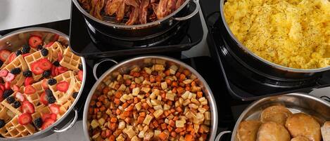 Una cocina con diversos platos, incluyendo gofres, verduras asadas y productos de repostería.
