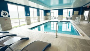 A swimming pool with clear water, a lifeguard chair, and a sign indicating no lifeguard on duty.