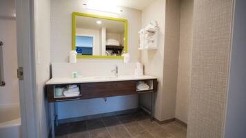A modern bathroom with a white sink, a mirror with a yellow frame, and a towel rack.