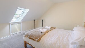 A bedroom with a skylight, a bed with white linens, a fluffy beige throw blanket, and a bedside lamp. - Dawson Park 2 - UK12661 (Mablethorpe)